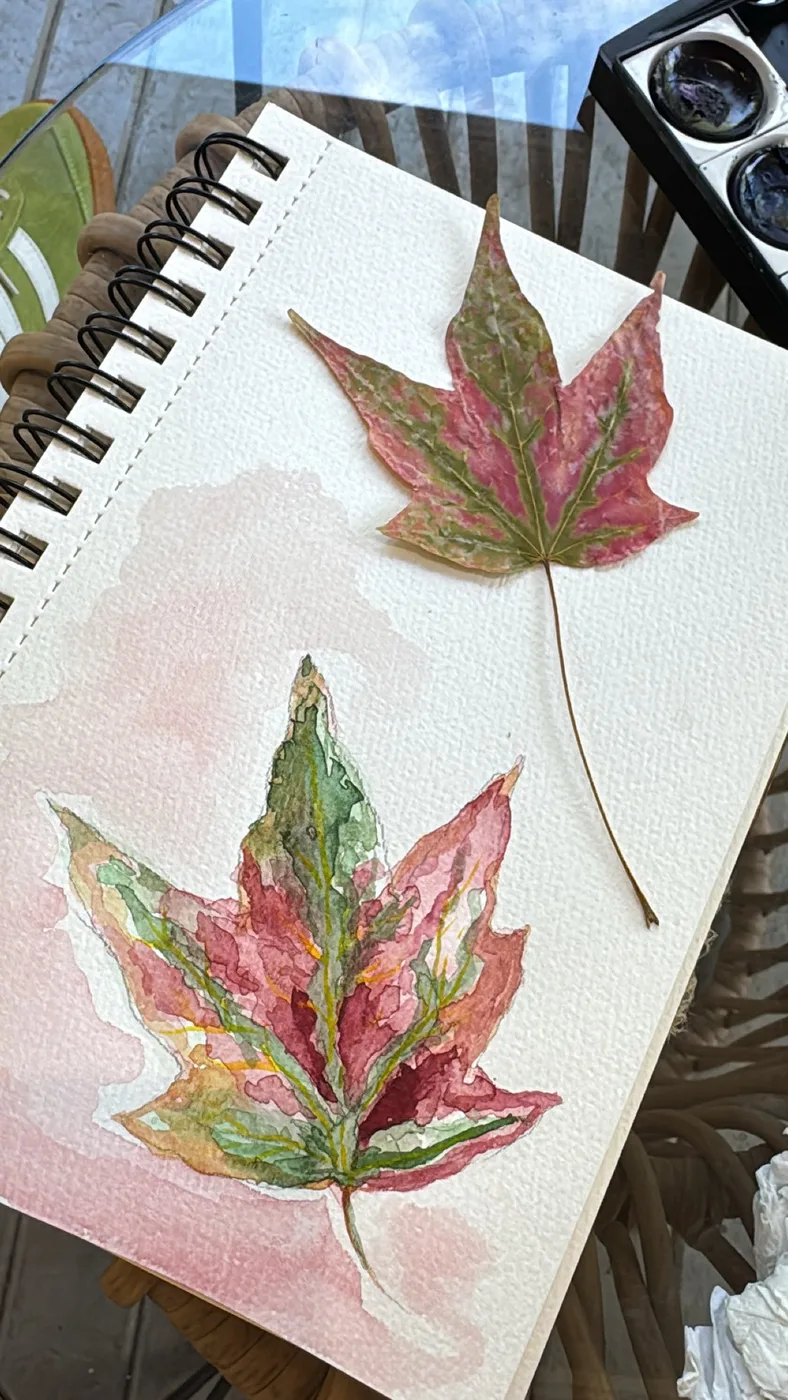 Watercolour maple leaves with a real leaf