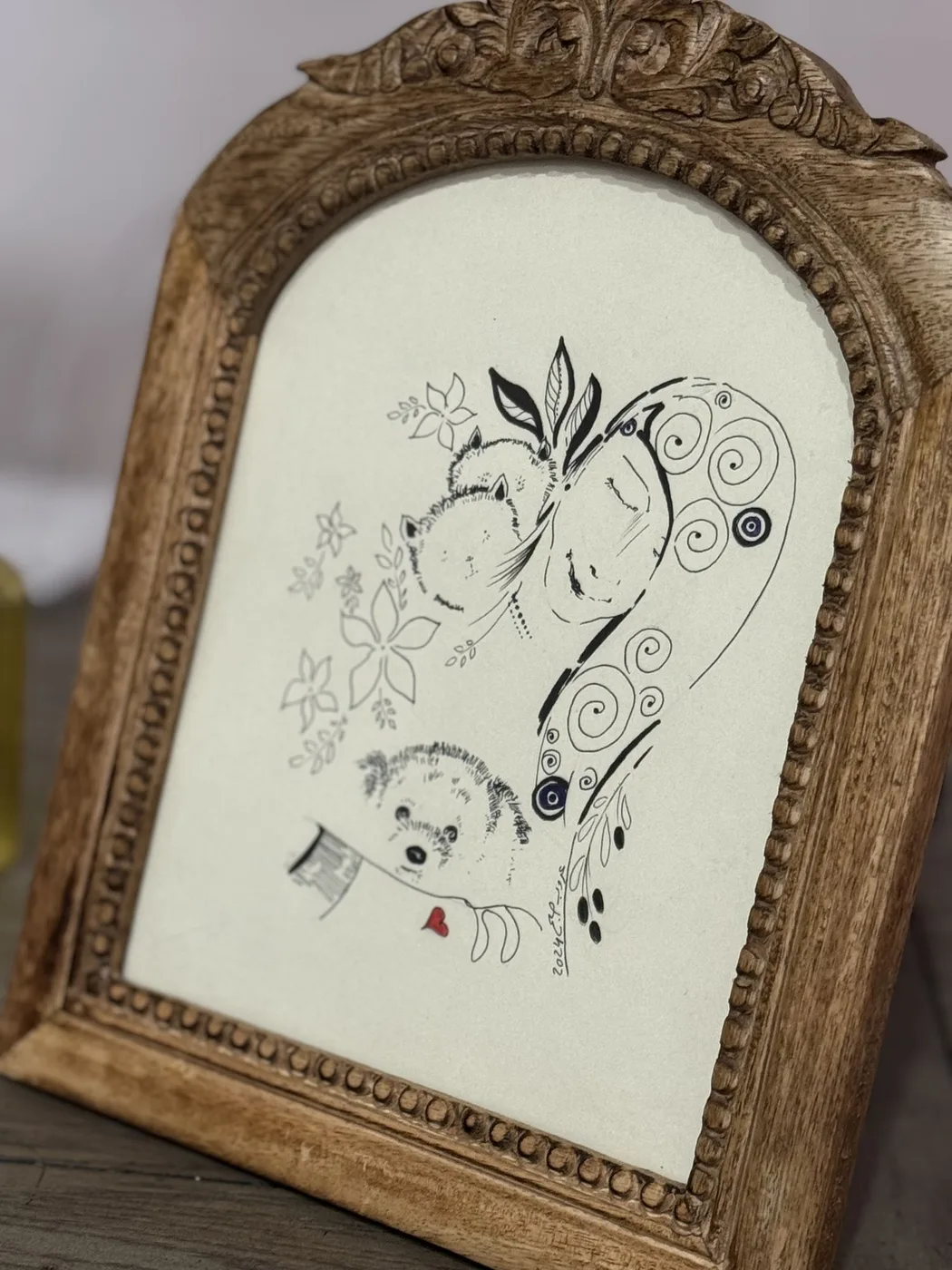Line drawing of woman and hedgehogs, carved frame