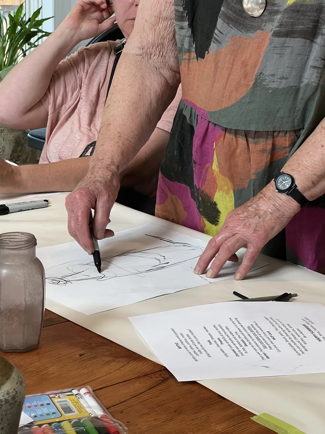 Older adult hands drawing with a black marker