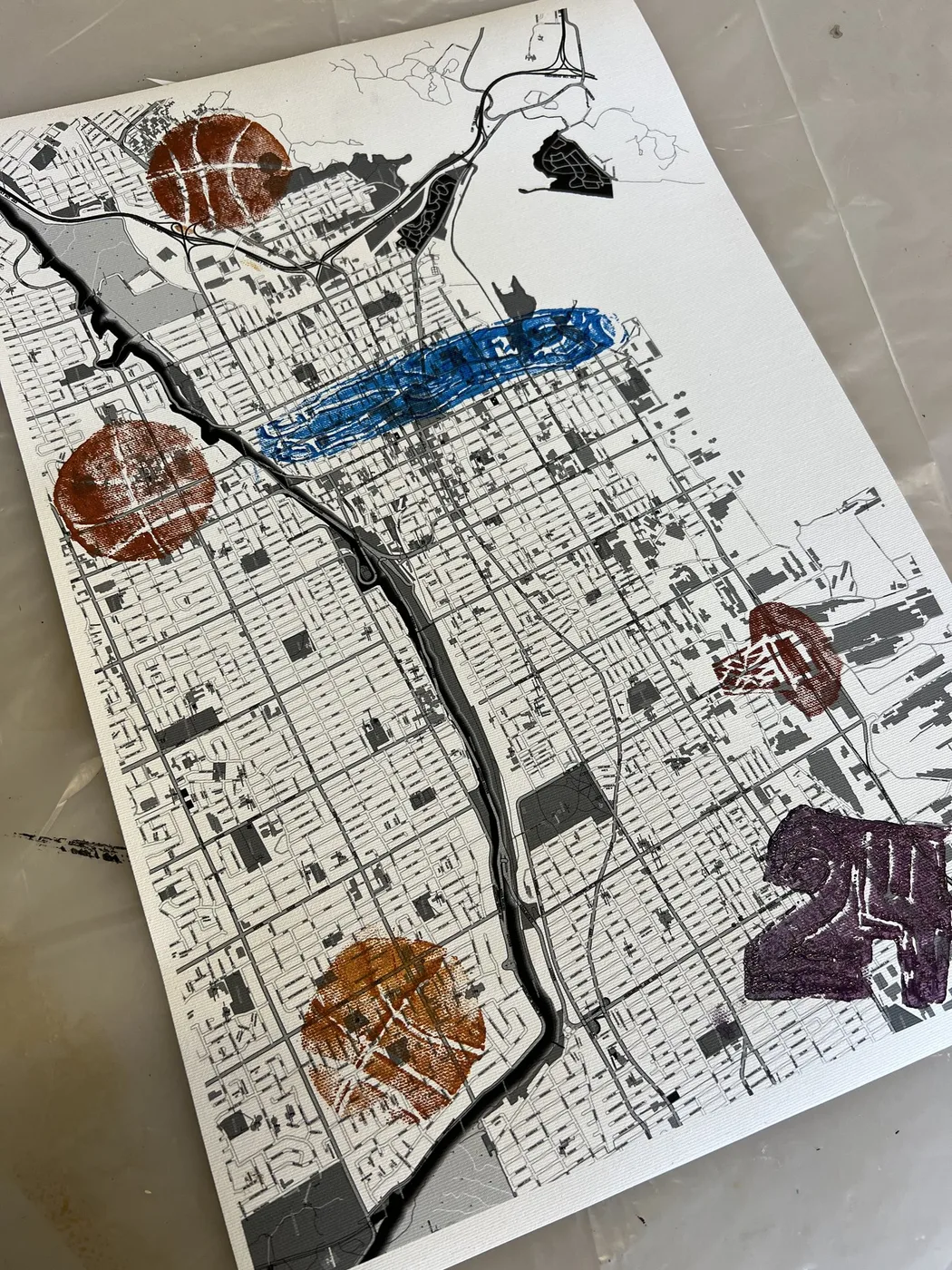 Map collage with painted river and cut-outs
