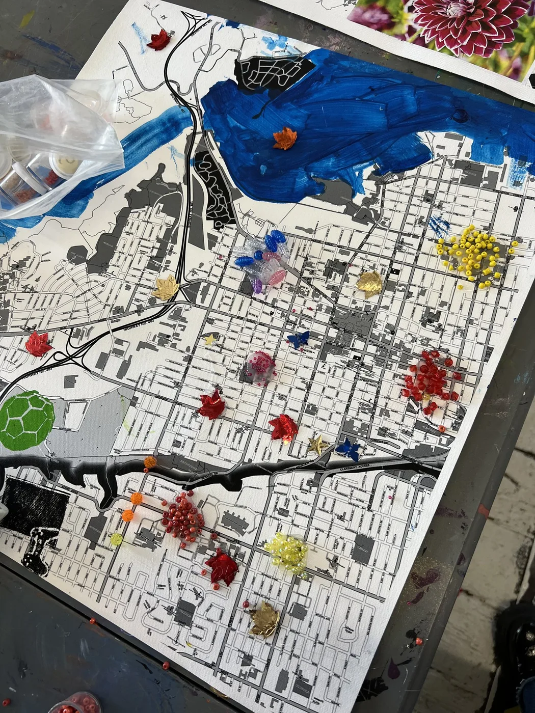 Map collage dotted with small paper flowers