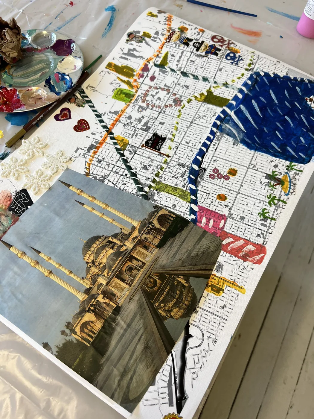 Map collage with a mosque photo and painted river