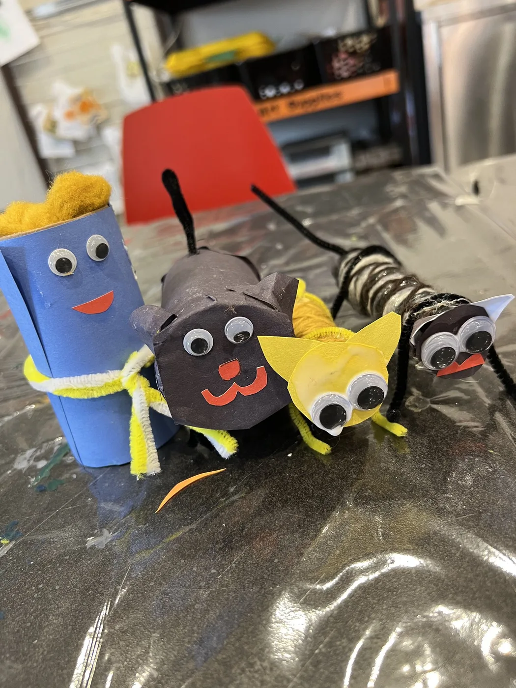 Tube characters: blue figure, black cat and striped bug