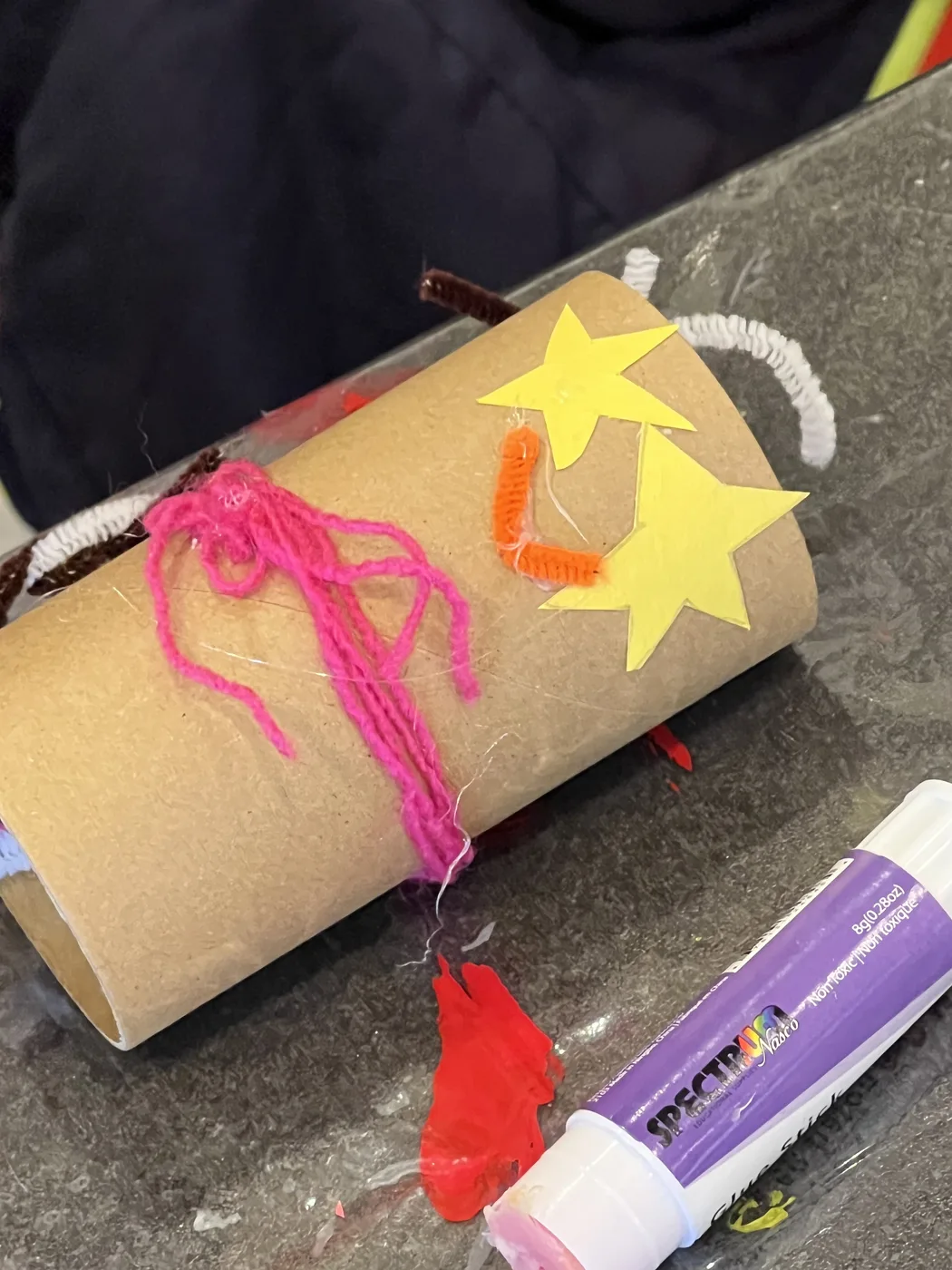 Tube on its side with stars and pink yarn