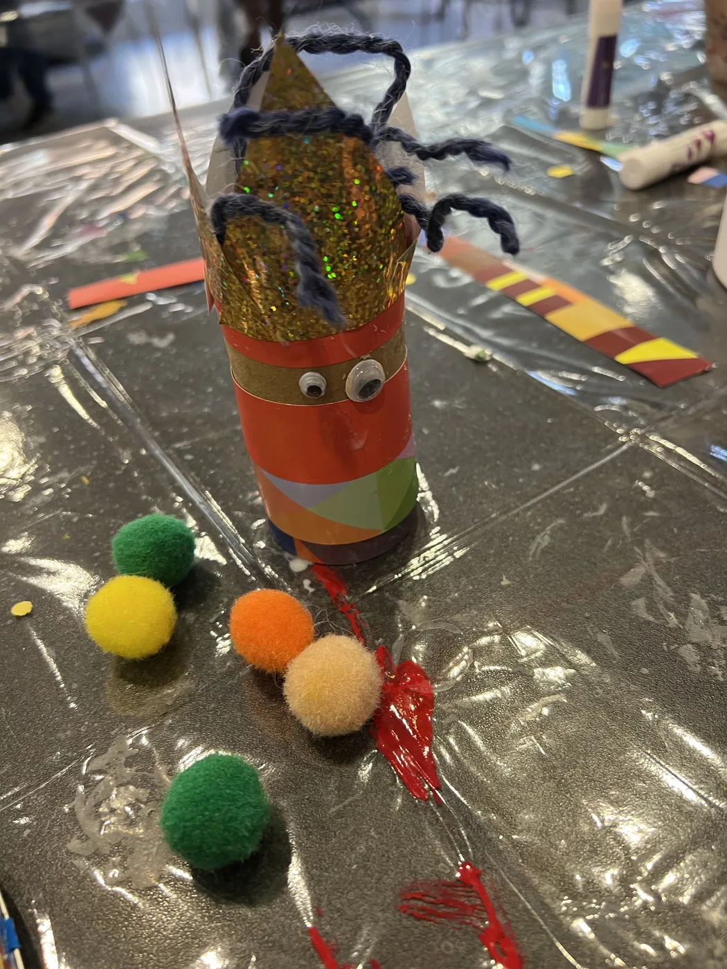 Tube figure with glitter crown and pompoms