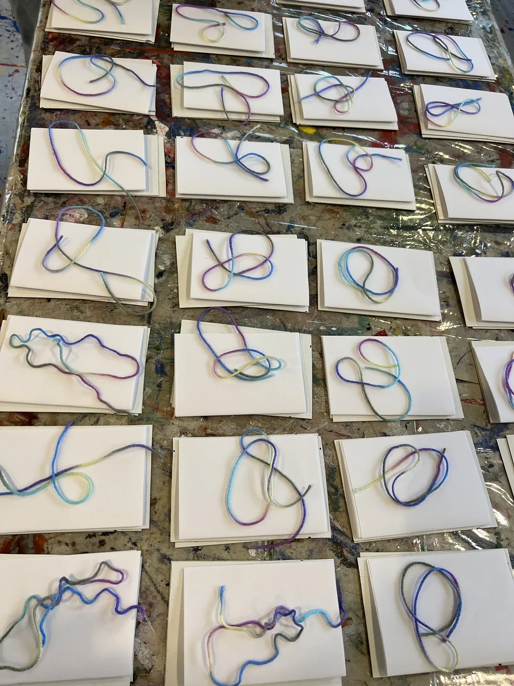 Rows of cards with coloured yarn line designs