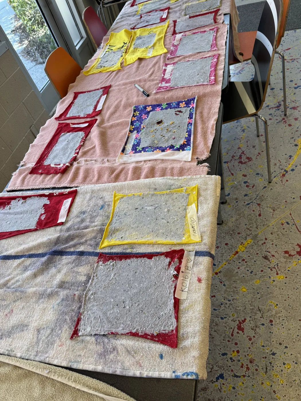 Handmade paper sheets drying along a long table
