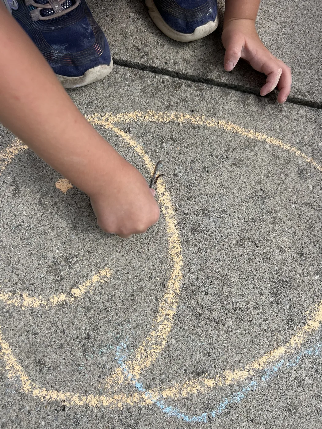 Hand drawing a big chalk circle on pavement