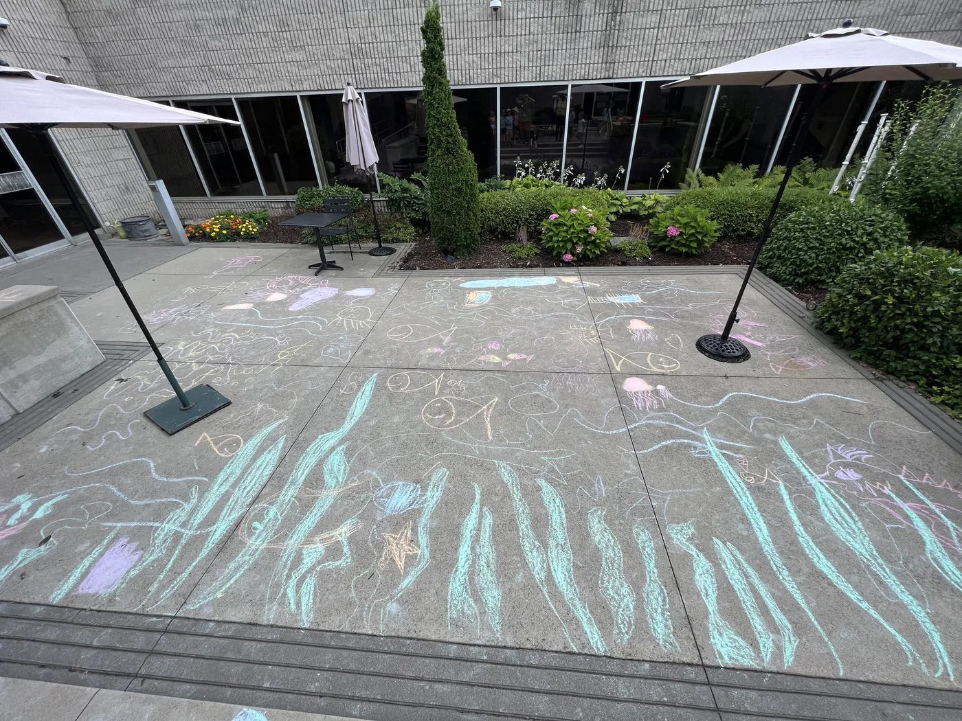 Chalk ocean mural across a sunny courtyard