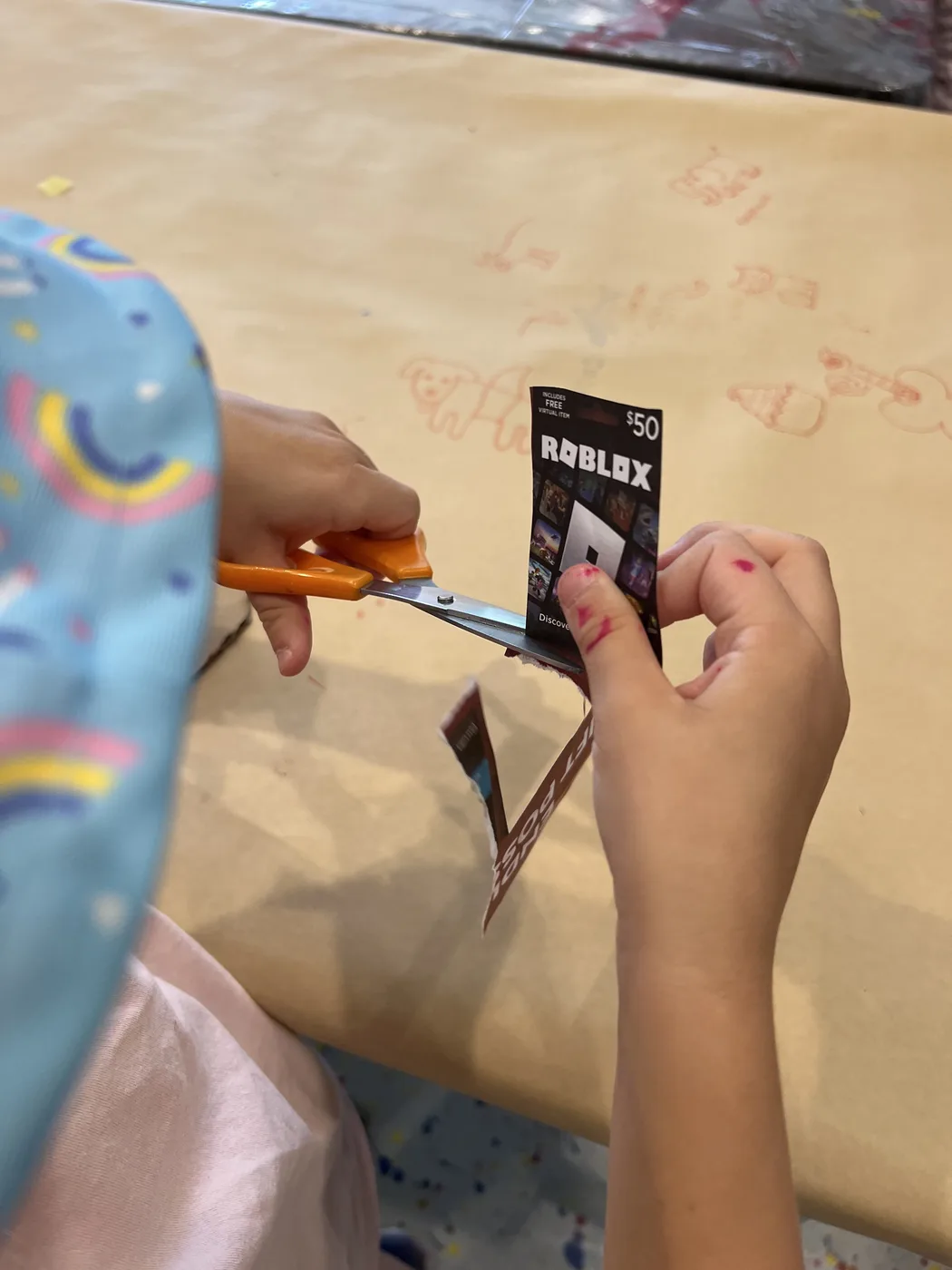 Hands cutting paper beside a gift card