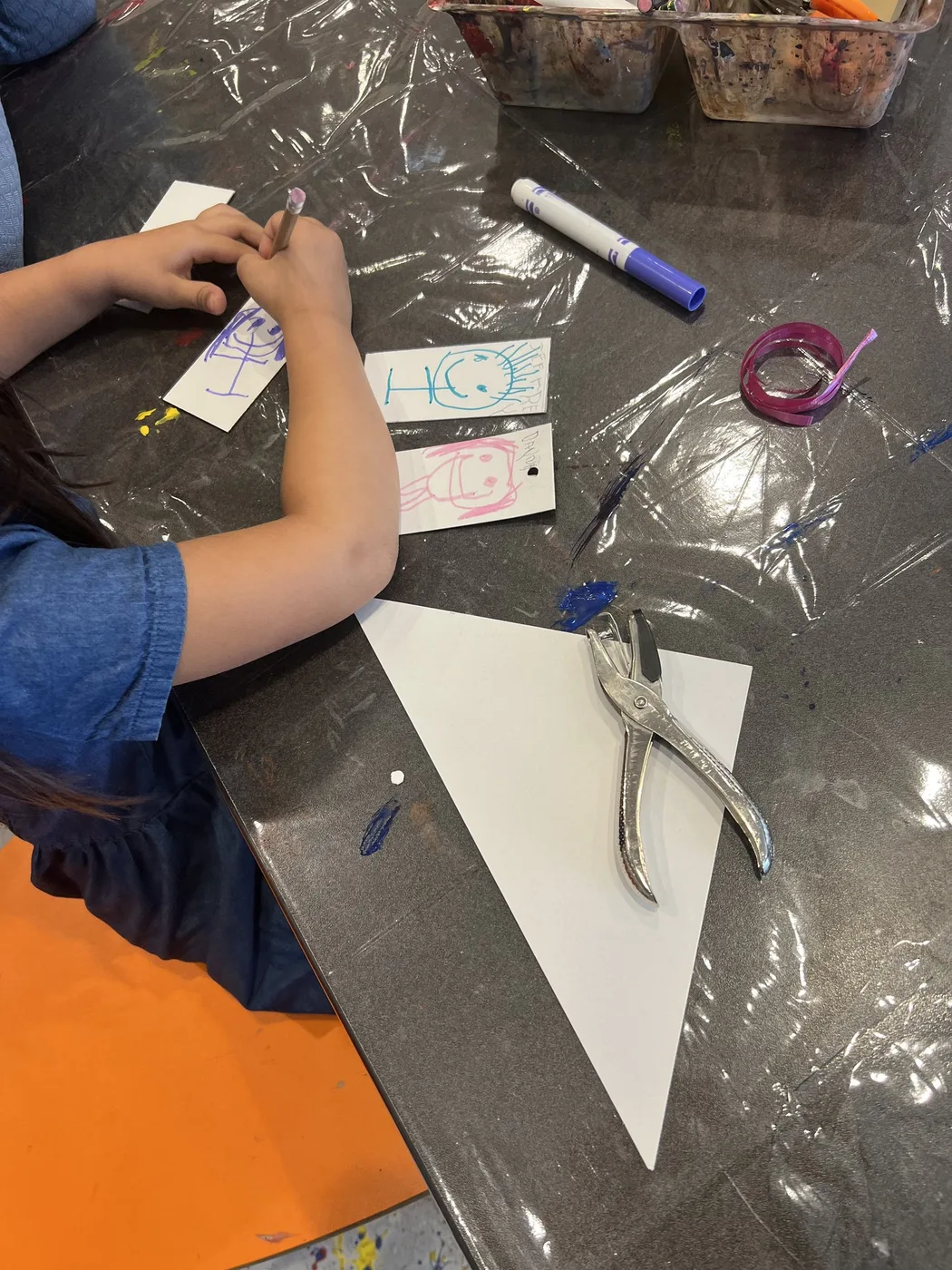 Hands writing name tags for a paper pennant