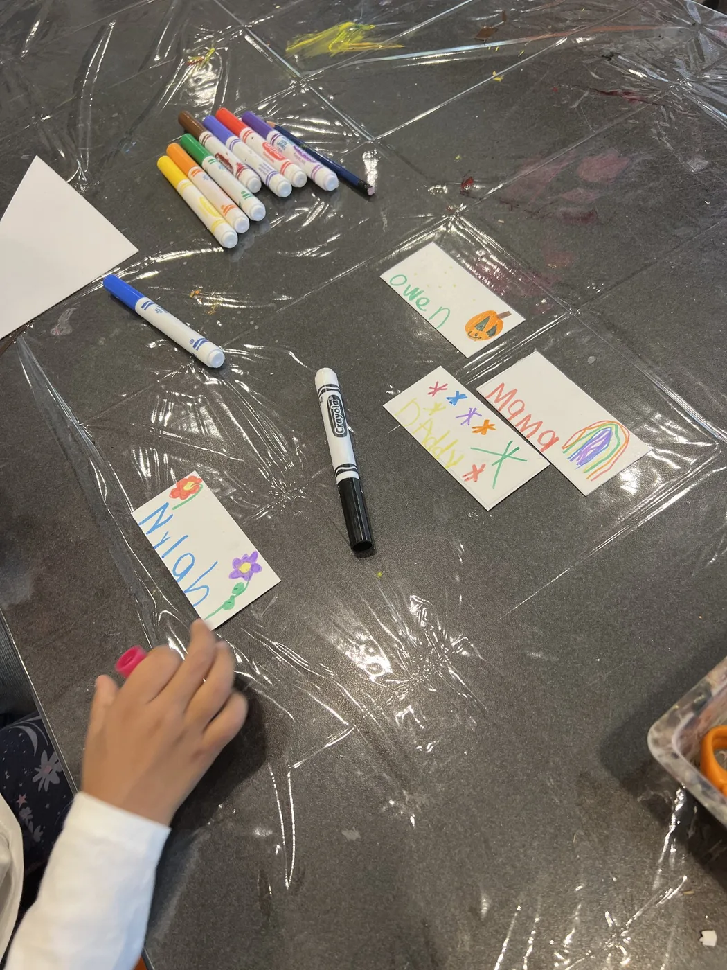 Markers and hand-lettered name tags on a table