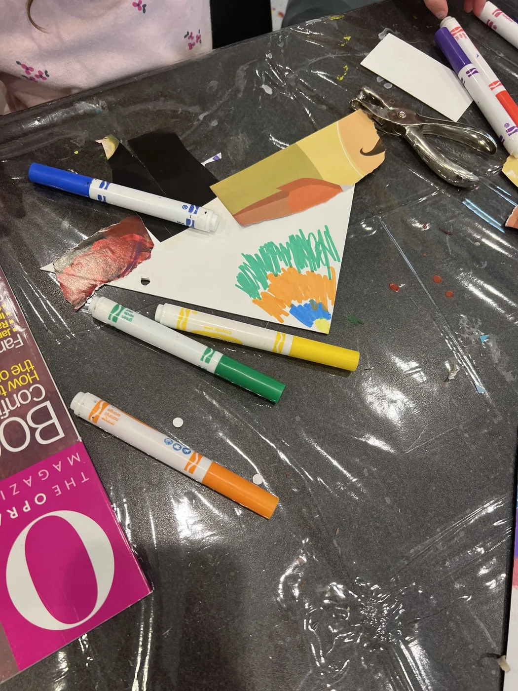 Marker-drawn pennant with a hole punch and markers