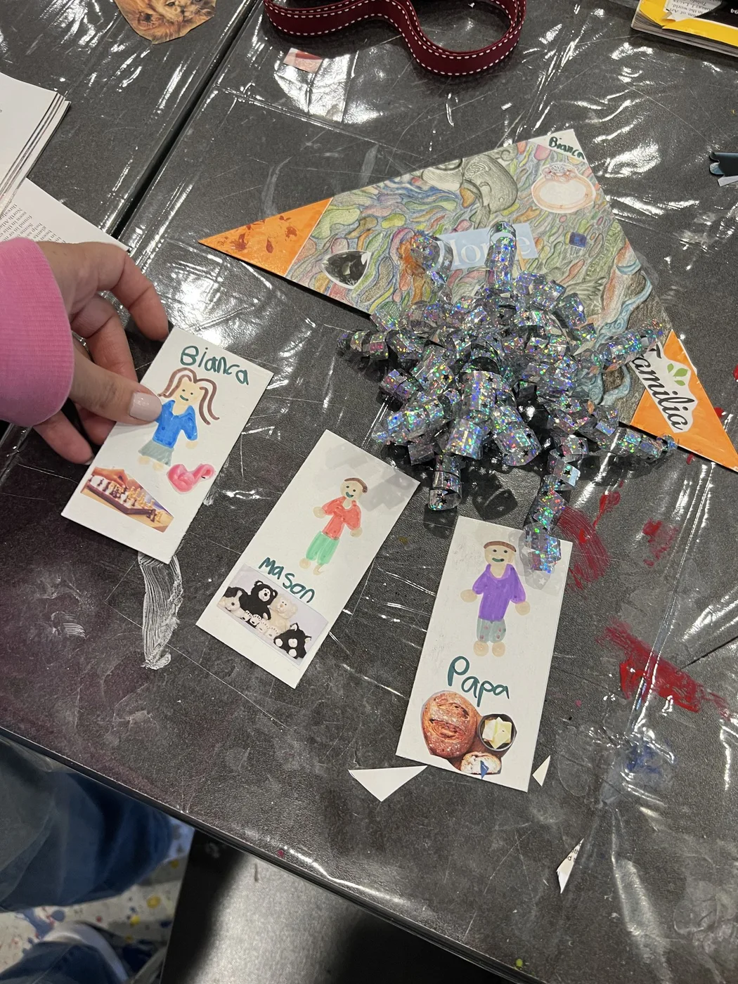 Hand-drawn family tags beside a shiny gift bow