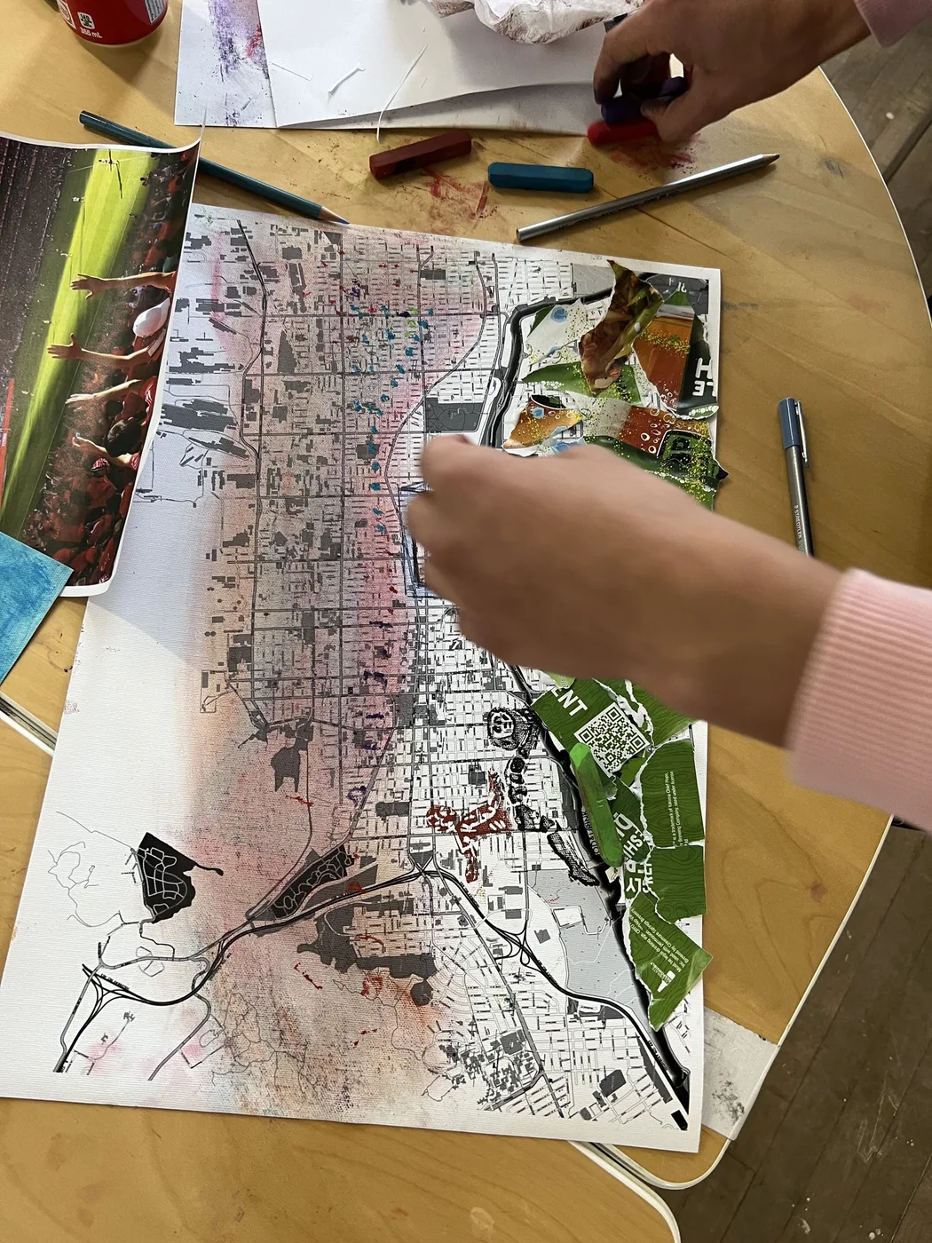 Hands working on a city map collage