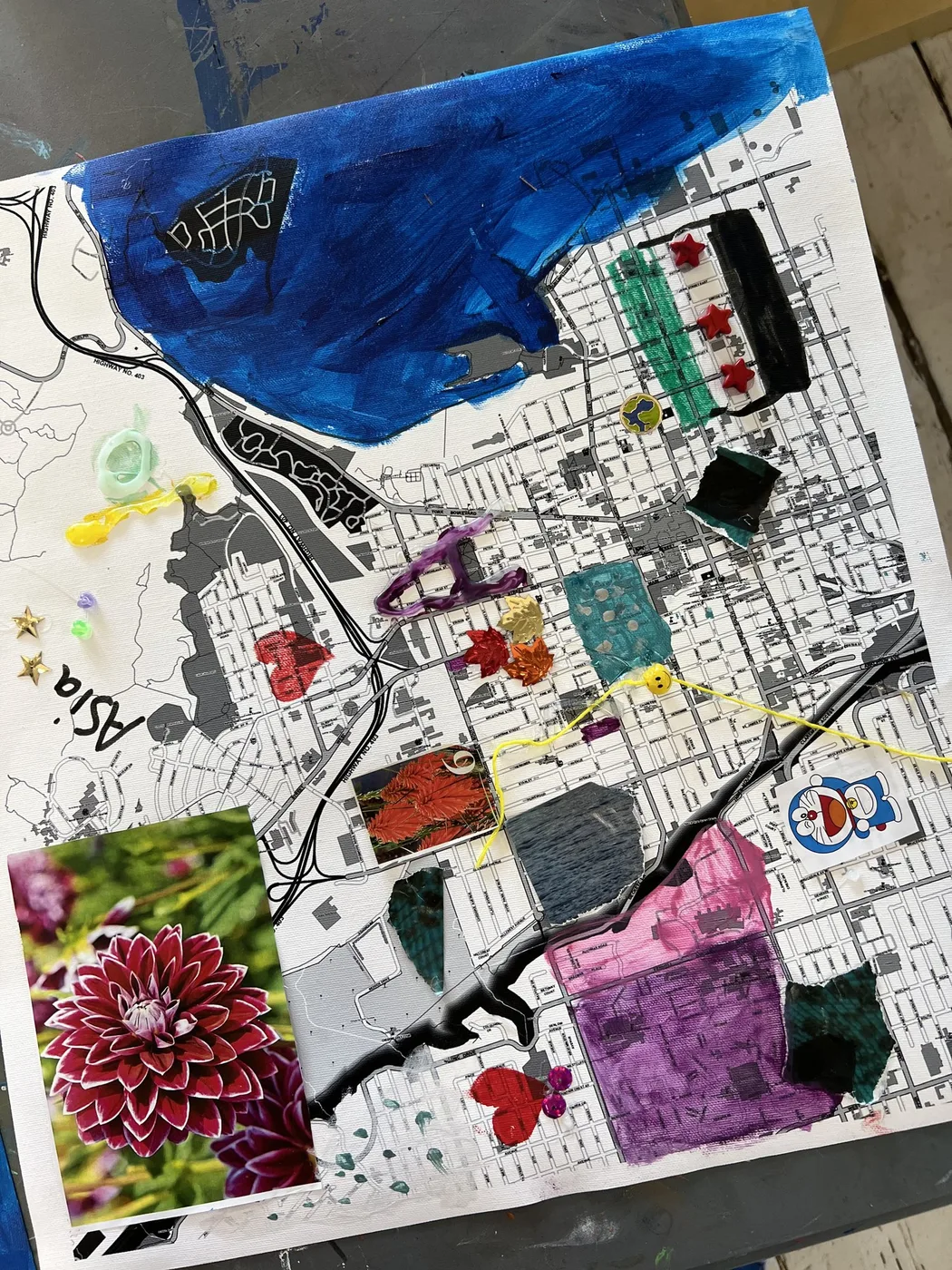 Map collage with painted water, photos and flags
