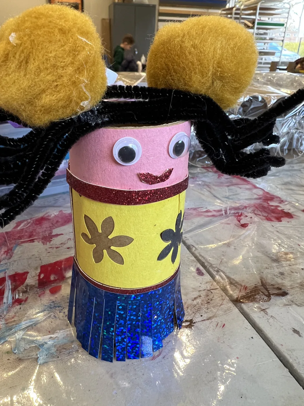 Tube doll with pom-pom buns and pipe-cleaner hair