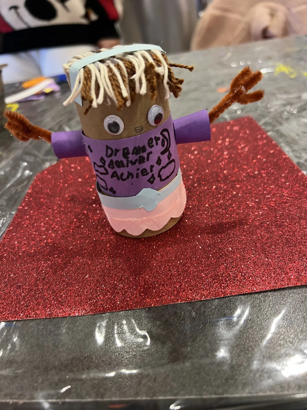 Tube doll with yarn hair and written words