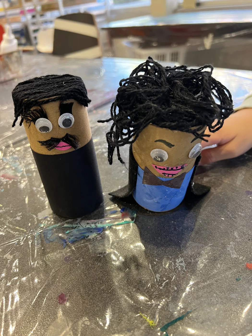 Two tube characters with black yarn hair