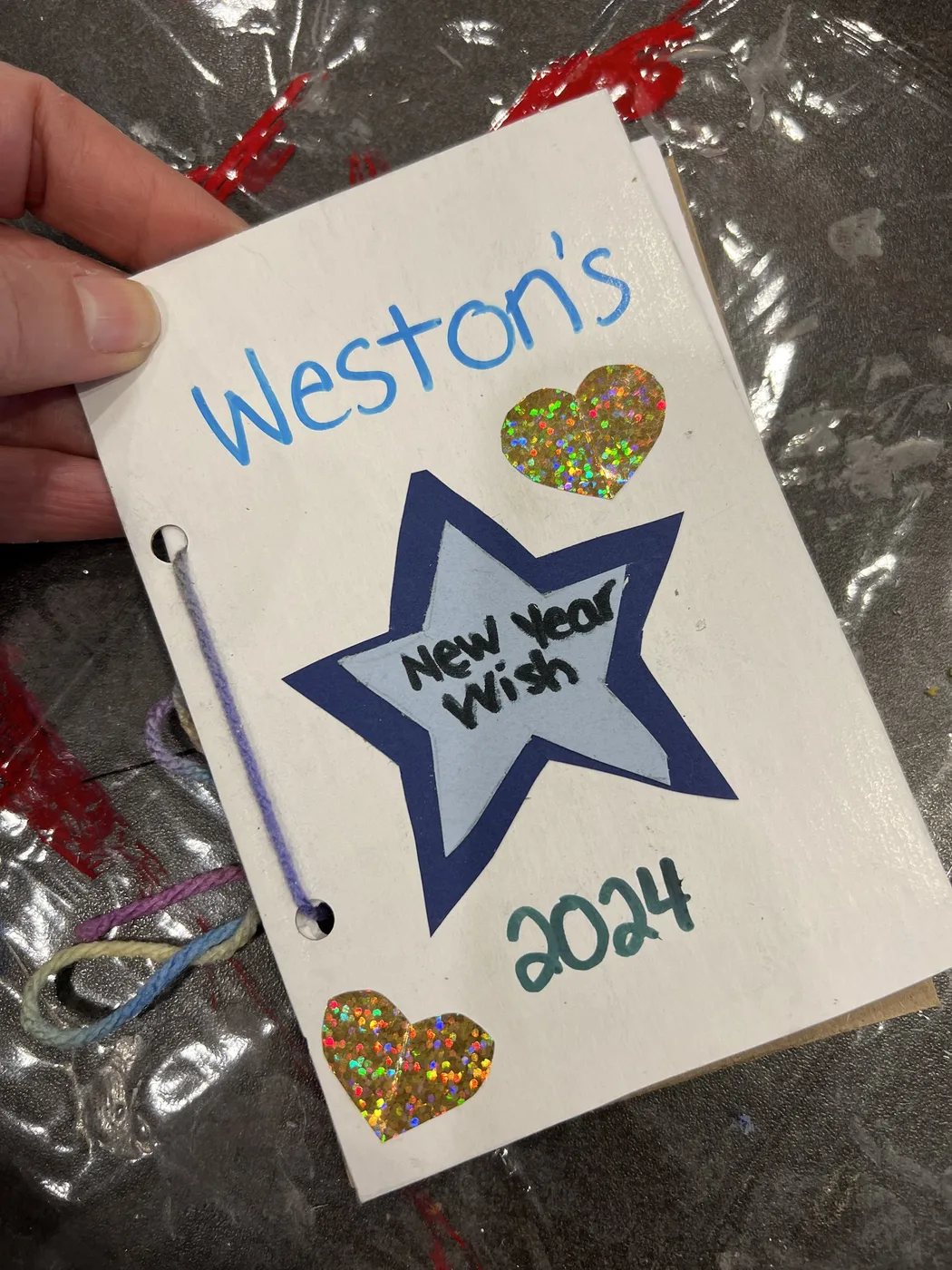 Hand holding a New Year wish book with star