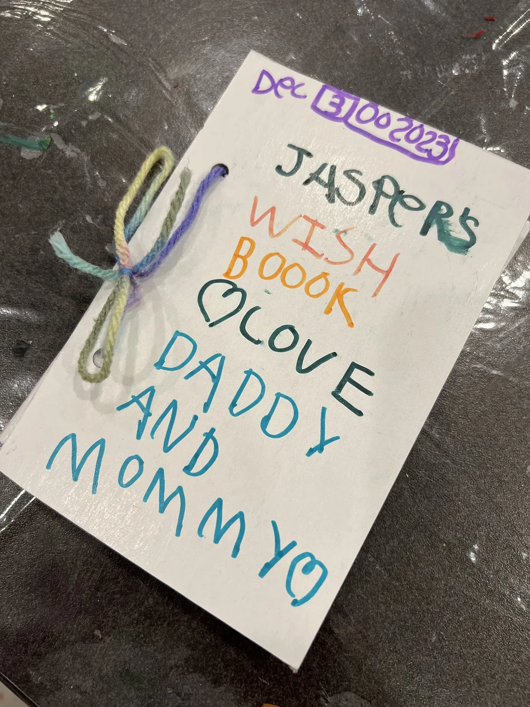 Hand-lettered wish book cover tied with yarn