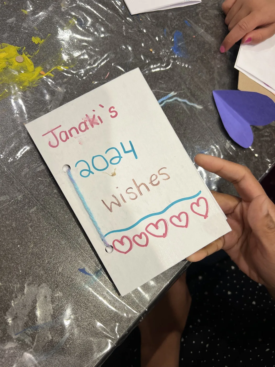 Hands holding a hand-lettered wish book cover