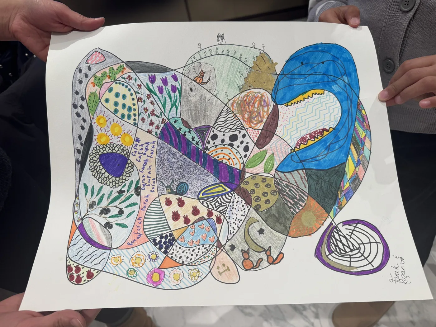 Hands holding up a finished colourful doodle drawing