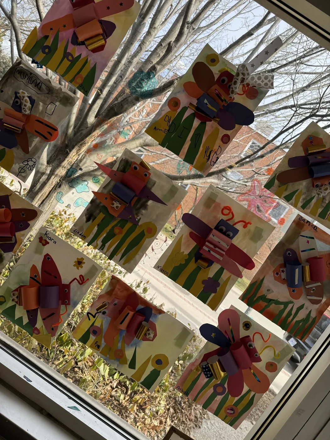 Paper butterfly collages taped on a window
