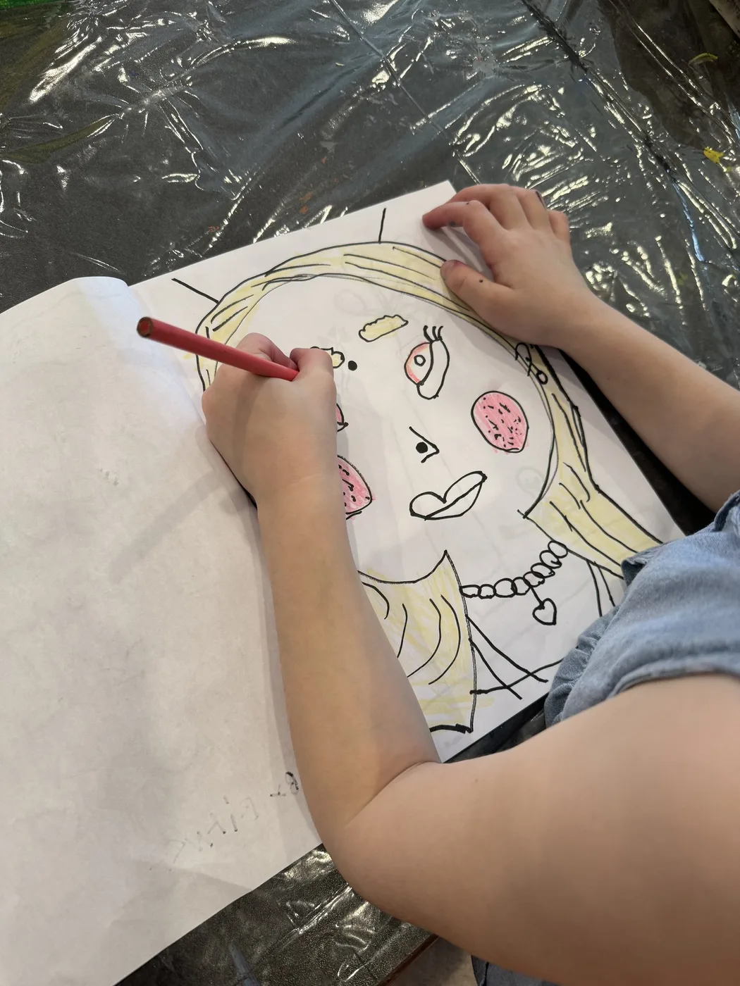 Hand colouring a large self-portrait drawing