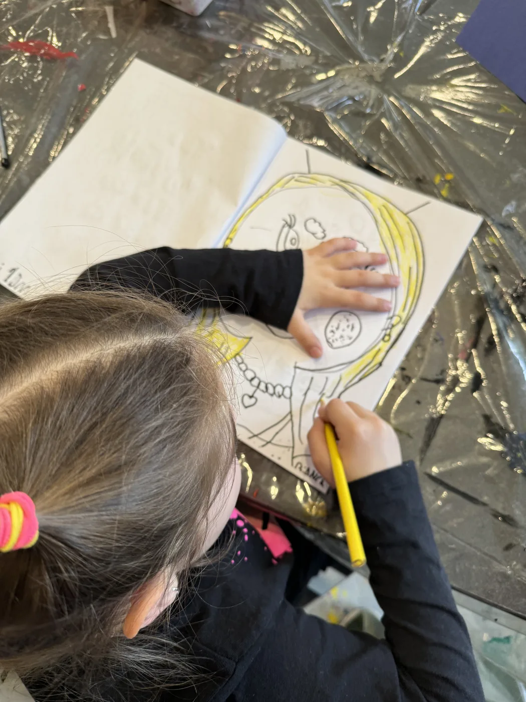 Child drawing a portrait in a sketchbook
