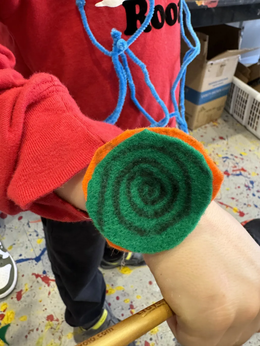 Wrist wearing a green felt spiral bracelet