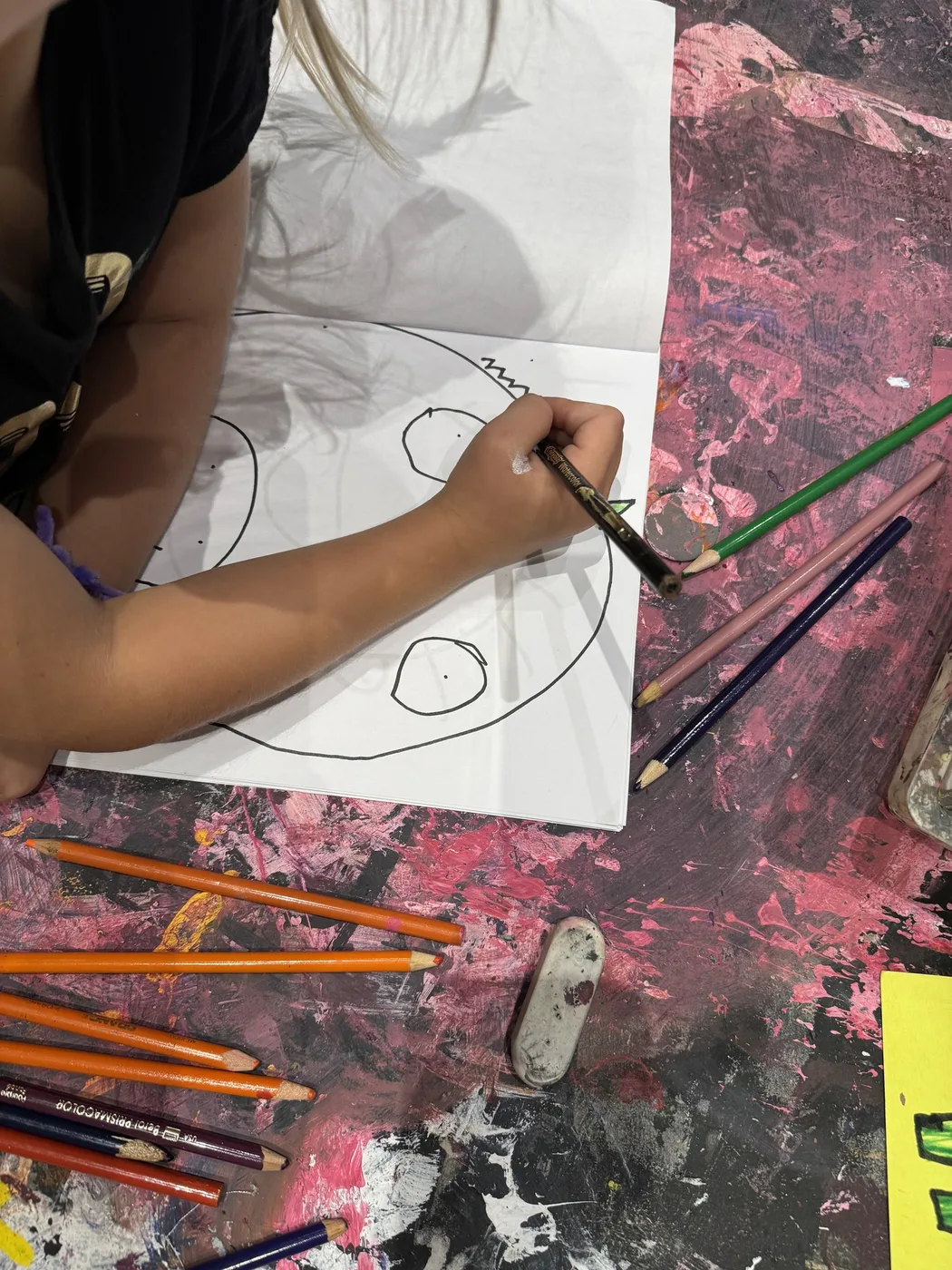 Hand outlining a fish drawing in pencil