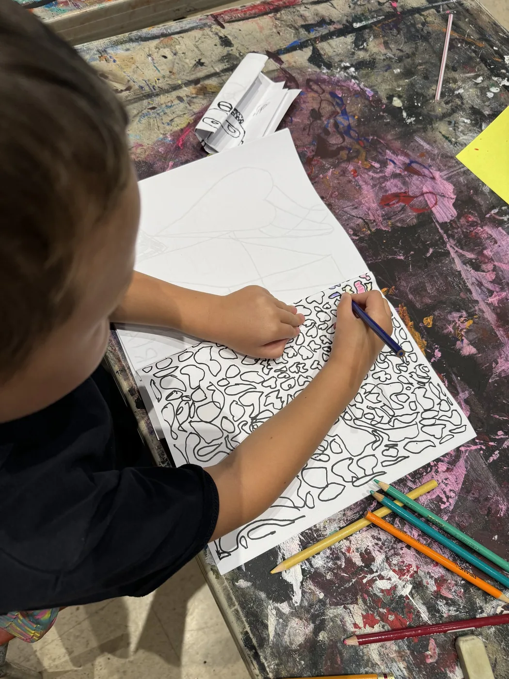 Hand filling a drawing with pebble patterns