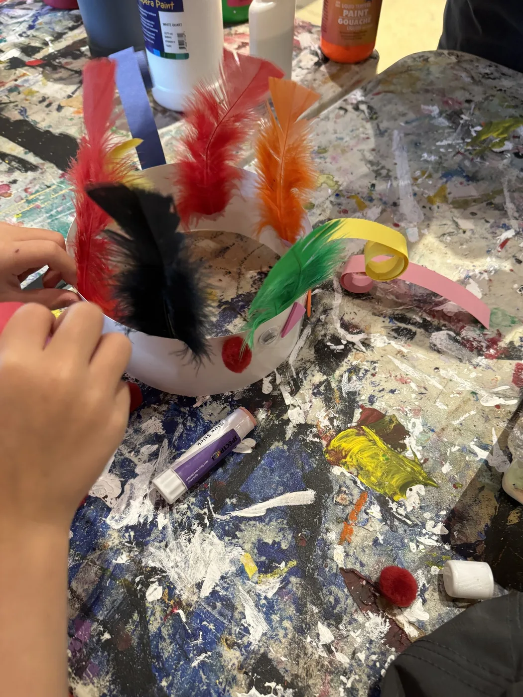 Paper crown with red, orange and black feathers