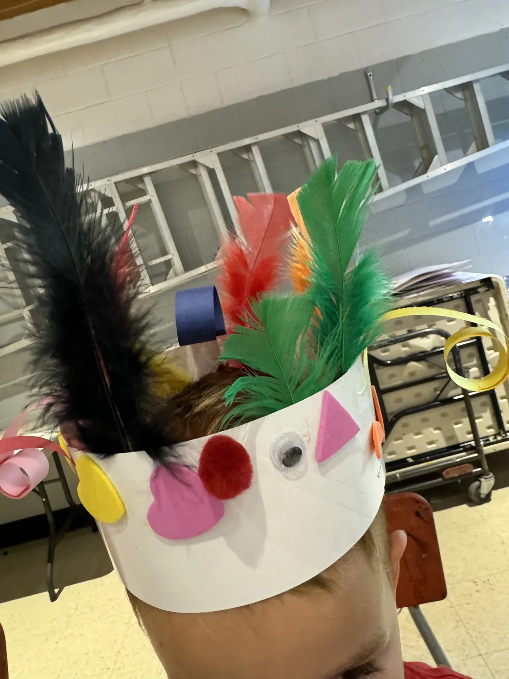 Feathered paper crown worn on a child’s head