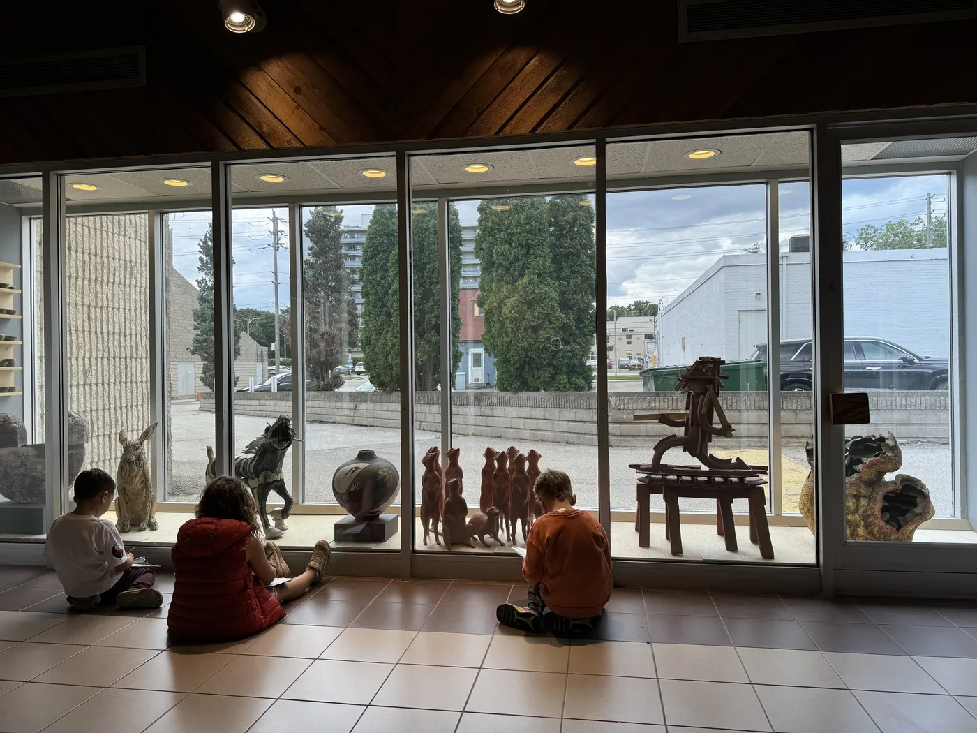 Children seen from behind looking at sculptures