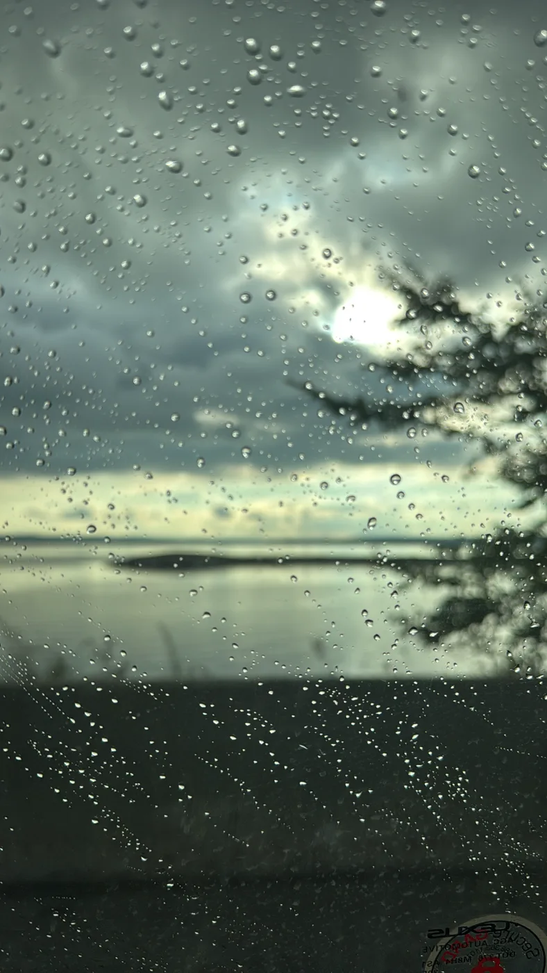 Raindrops on glass in front of the water