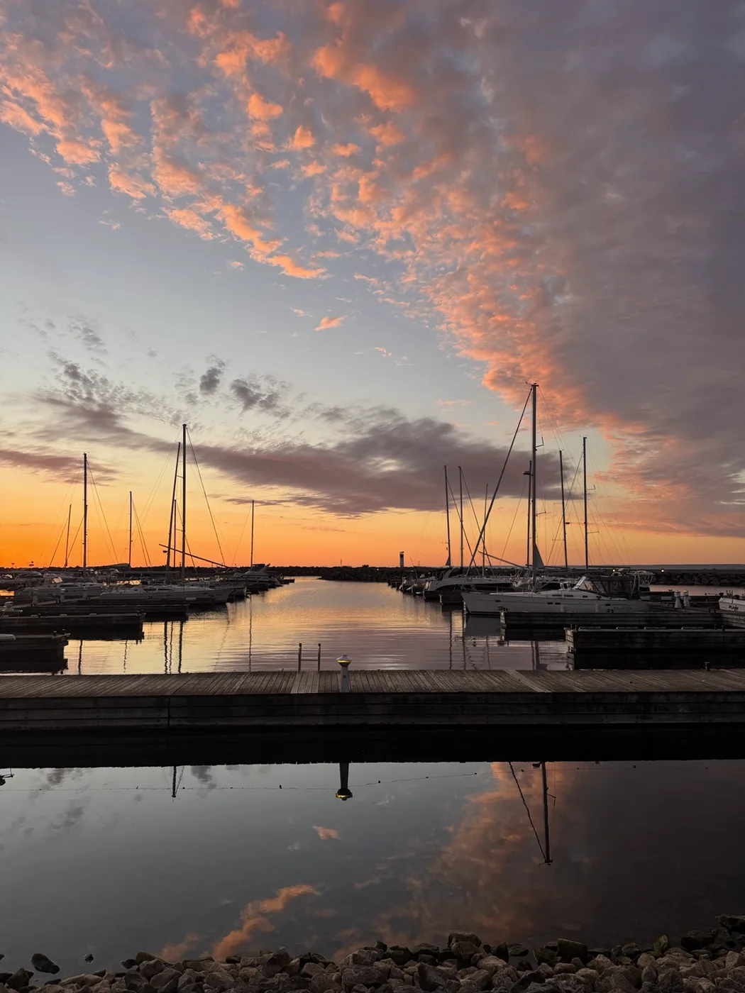 Sailboat masts beneath pink evening clouds