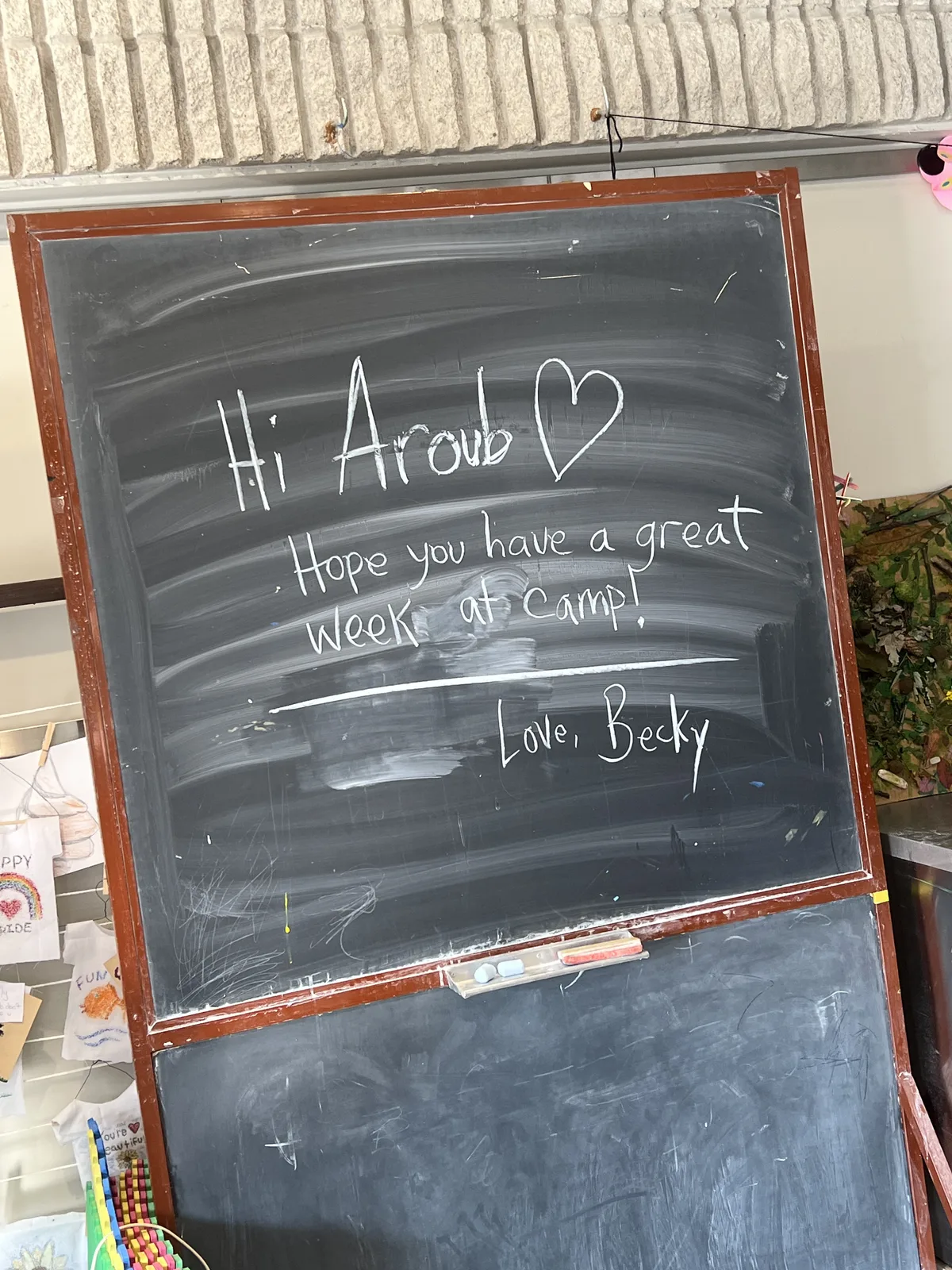 Chalkboard welcome message: "Hi Aroub, hope you have a great week at camp! Love, Becky"