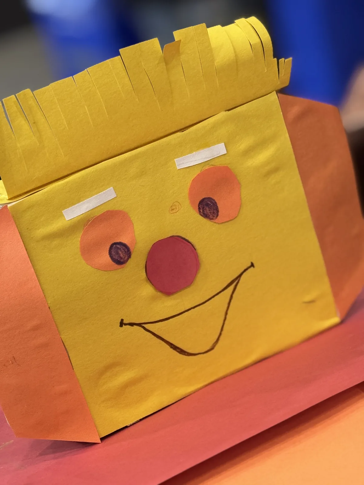 A yellow paper bag puppet character craft