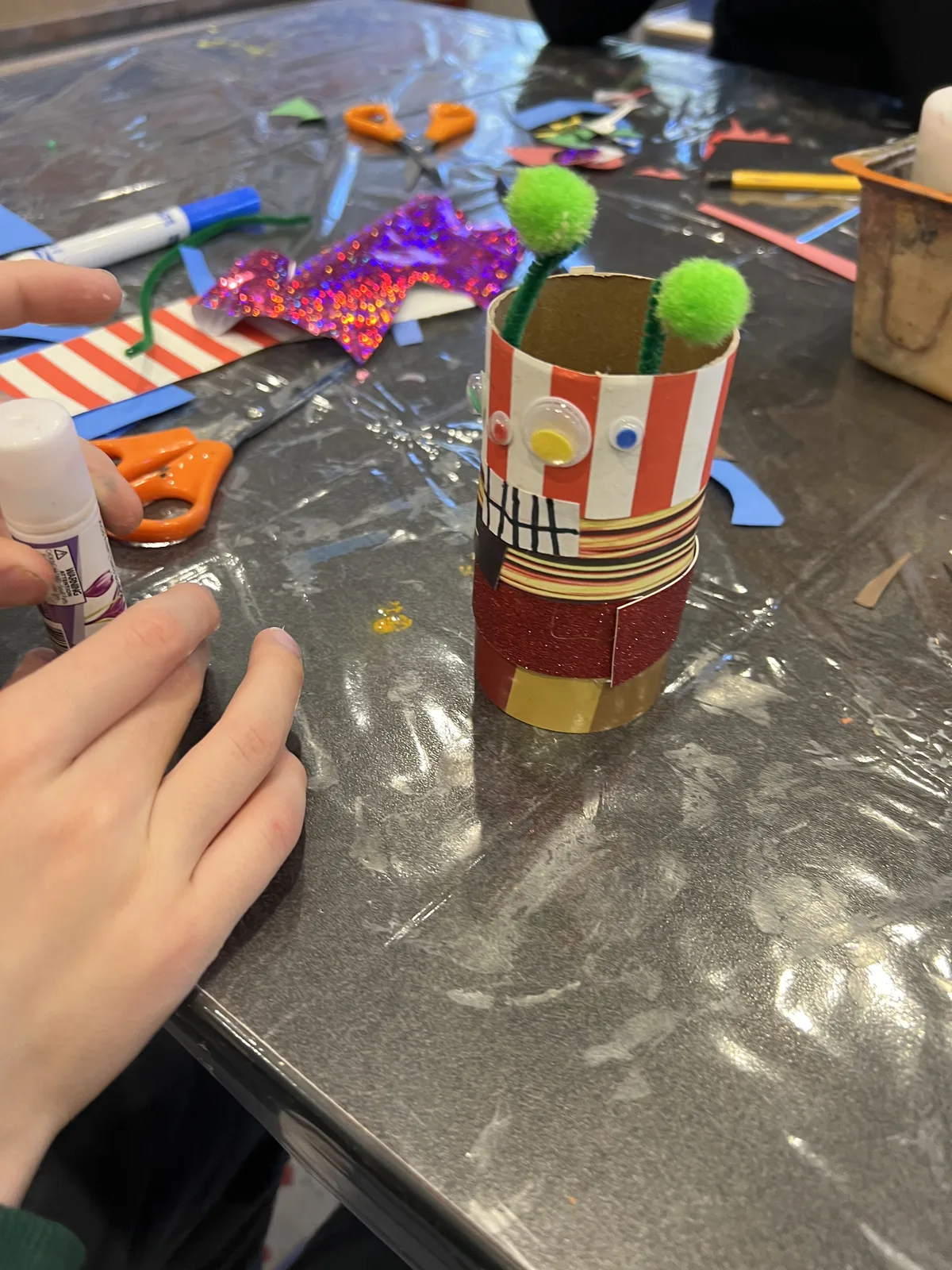 A cardboard tube robot craft with pom-pom antennae