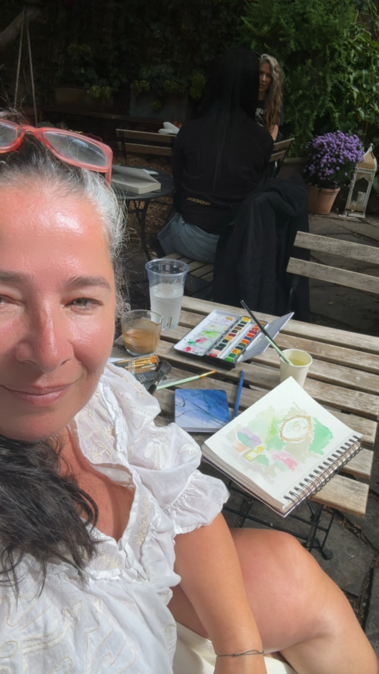 Aroub beside her paints and courtyard sketchbook