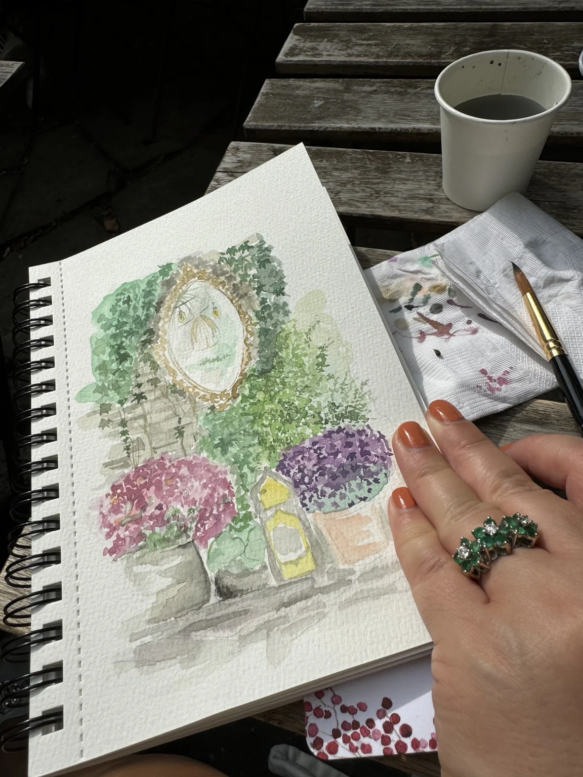Finished courtyard watercolour beside a paintbrush