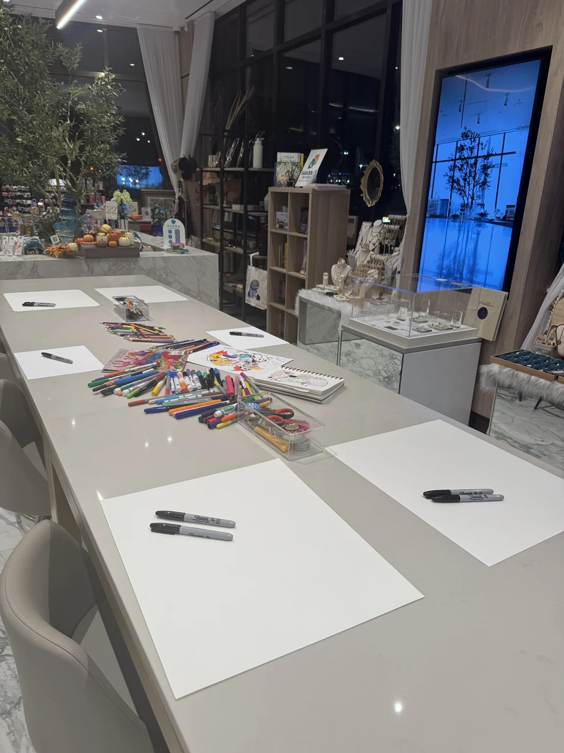 Long table set with paper and coloured pens