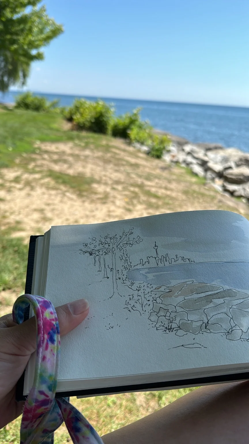 Pencil drawing of the lake held in front of the shore
