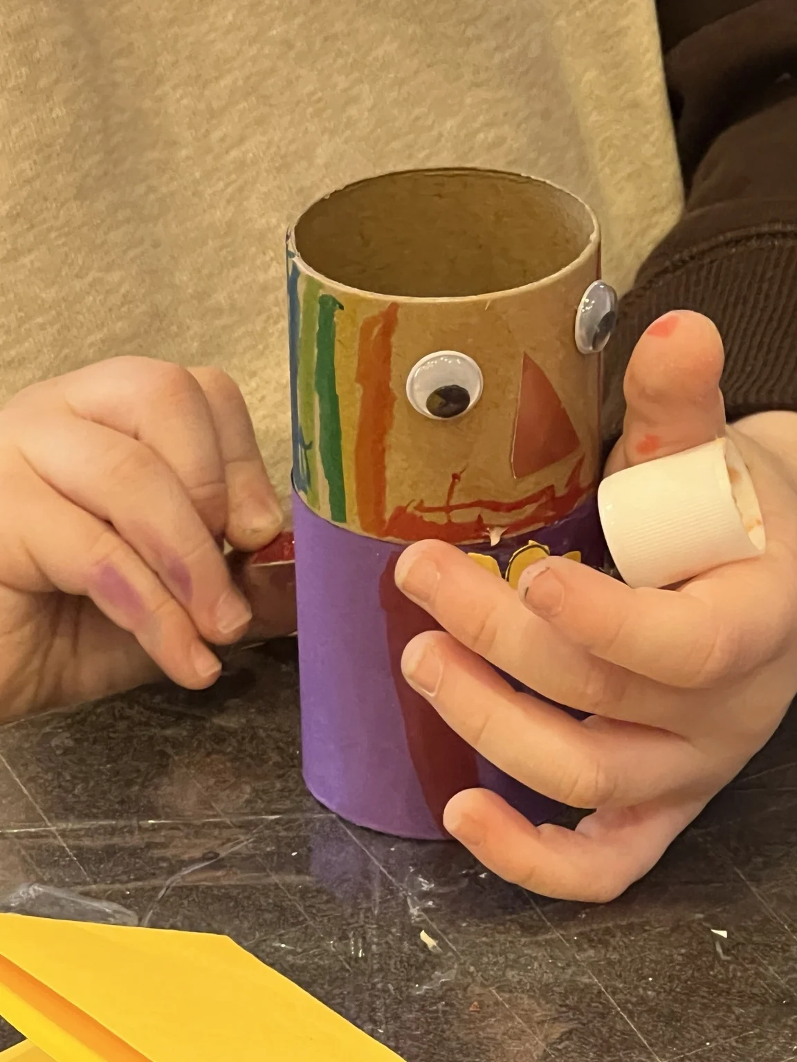 Small hands shaping a paper character