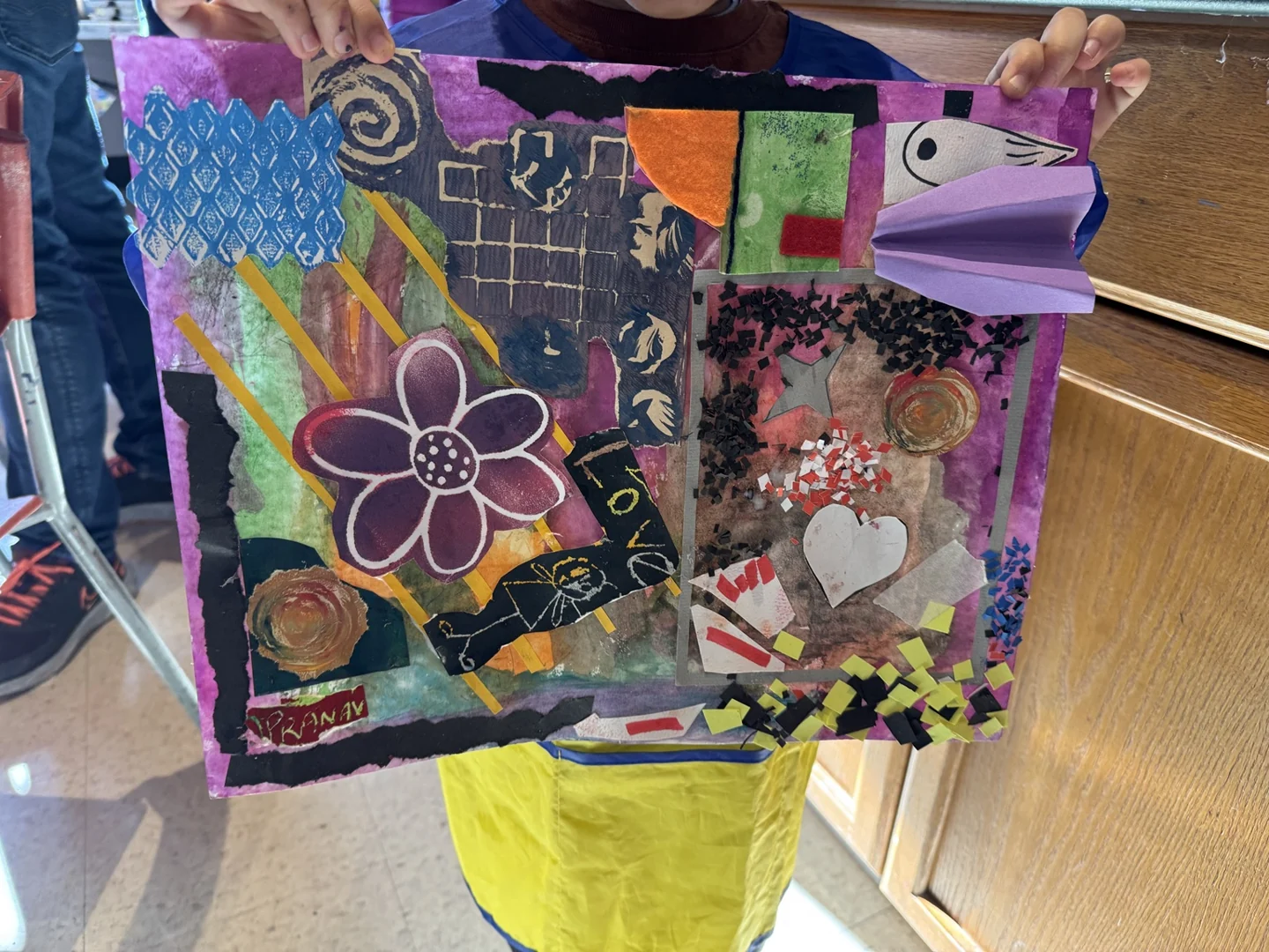 A finished paper collage held up