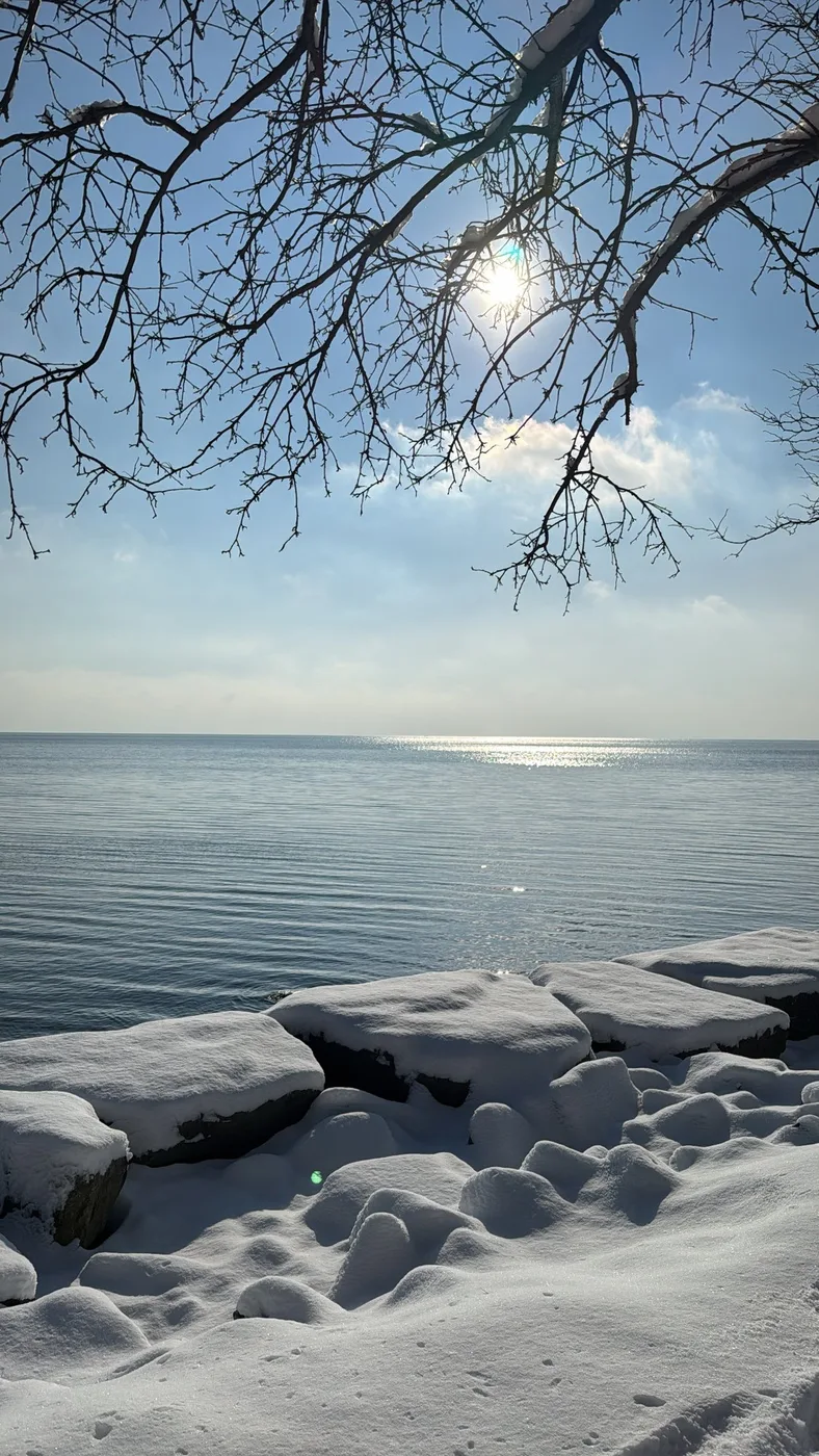 Snow on the shore, winter light on the lake